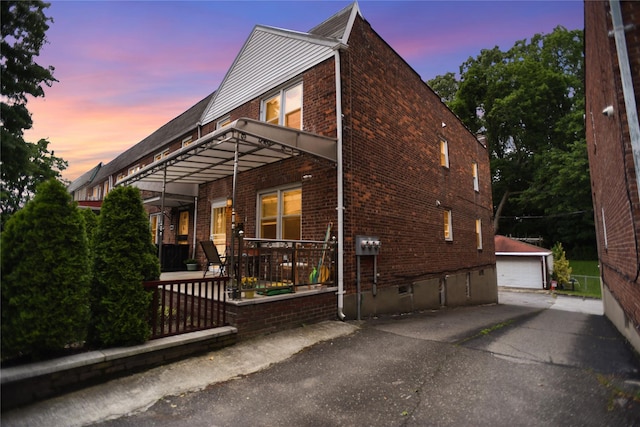 6848 Selfridge St, Forest Hills, NY 11375 - view of home's exterior with brick siding, a detached garage, and an outbuilding