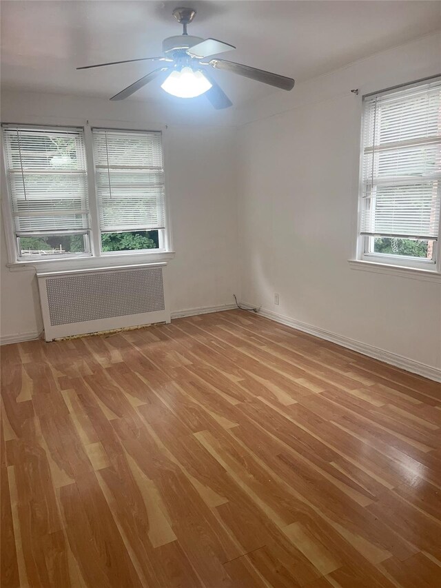 6848 Selfridge St, Forest Hills, NY 11375 - spare room featuring radiator, light wood-style flooring, ceiling fan, and baseboards