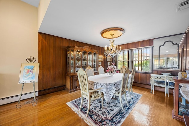 797 Caldwell Ave, North Woodmere, NY 11581 - dining room with wood walls, a chandelier, a baseboard radiator, and wood finished floors