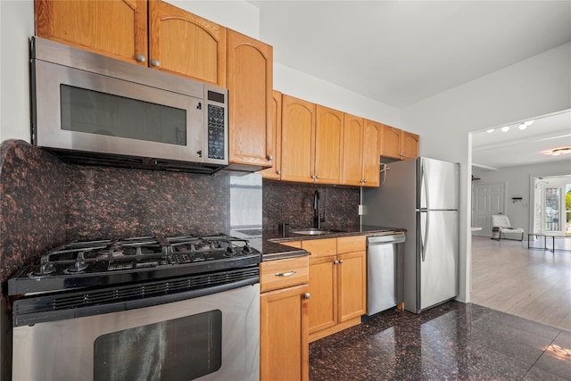 21-38 73rd St, Astoria, NY 11370 - kitchen featuring appliances with stainless steel finishes, a sink, dark countertops, granite tiled floors, and decorative backsplash