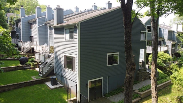 13 Timber Rdg, Mount Kisco, NY 10549 - rear view of house featuring central AC, a chimney, a lawn, and stairs