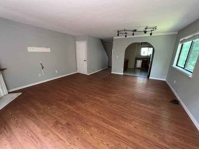 13 Timber Rdg, Mount Kisco, NY 10549 - unfurnished living room with arched walkways, wood finished floors, baseboards, and track lighting
