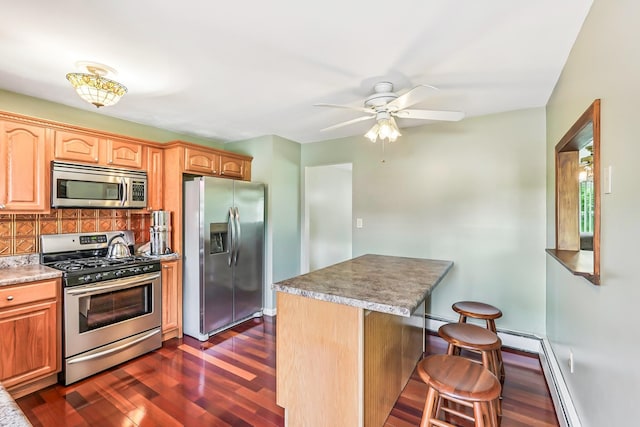 304 Cloverdale Ct, New Windsor, NY 12553 - kitchen with appliances with stainless steel finishes, a breakfast bar, dark wood finished floors, backsplash, and ceiling fan