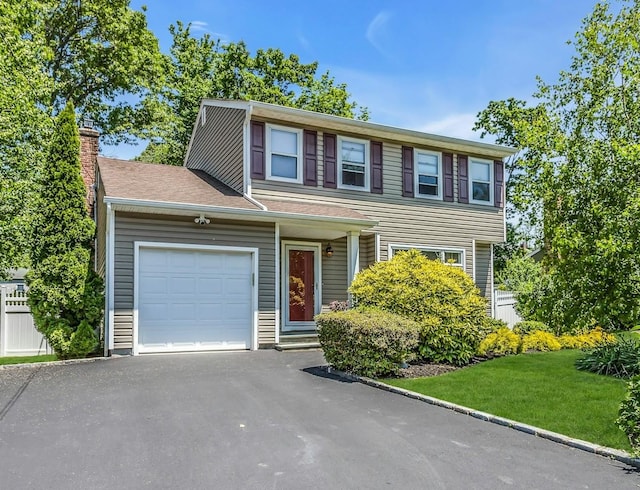 14 Troy Ct, Northport, NY 11768 - view of front of property featuring an attached garage, asphalt driveway, a chimney, and a front yard