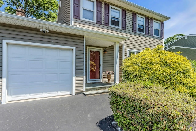 14 Troy Ct, Northport, NY 11768 - view of front of house with a chimney, a garage, and asphalt driveway