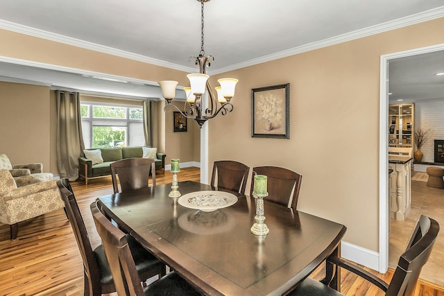 14 Troy Ct, Northport, NY 11768 - dining space featuring crown molding, a chandelier, light wood finished floors, and baseboards