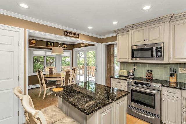 14 Troy Ct, Northport, NY 11768 - kitchen featuring stainless steel appliances, cream cabinetry, light tile patterned floors, tasteful backsplash, and ornamental molding