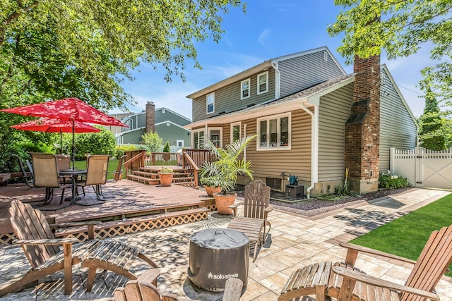 14 Troy Ct, Northport, NY 11768 - rear view of property featuring a deck, a patio, a gate, a chimney, and outdoor dining space