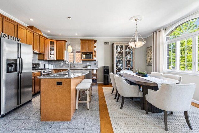 20407 29th Ave, Bayside, NY 11360 - kitchen with appliances with stainless steel finishes, a sink, brown cabinetry, a center island with sink, and recessed lighting