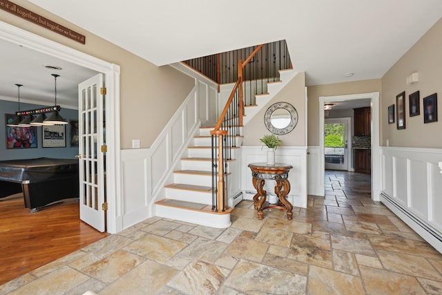 30 Sunrise Rdg, Florida, NY 10921 - staircase with a decorative wall, stone tile floors, a baseboard heating unit, and a wainscoted wall