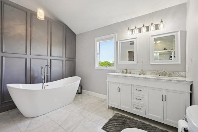 30 Sunrise Rdg, Florida, NY 10921 - bathroom with double vanity, a freestanding tub, marble finish floors, vaulted ceiling, and baseboards