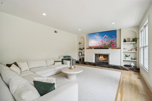3 Sugar Maple Ct, Dix Hills, NY 11746 - living room with built in features, wood finished floors, a glass covered fireplace, and recessed lighting