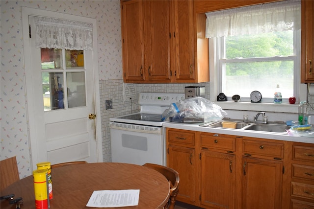 25 Alda Dr, Poughkeepsie, NY 12603 - kitchen with electric range, wallpapered walls, a sink, light countertops, and brown cabinets