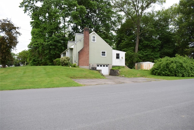 25 Alda Dr, Poughkeepsie, NY 12603 - view of side of property with asphalt driveway, a garage, a chimney, and a lawn