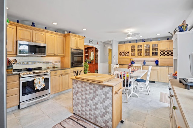 8 Jackson Ave, Hampton Bays, NY 11946 - kitchen featuring appliances with stainless steel finishes, arched walkways, backsplash, light tile patterned floors, and recessed lighting