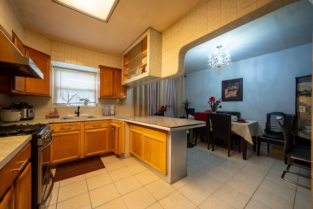32-23 76th St, East Elmhurst, NY 11370 - kitchen with stainless steel gas stove, a chandelier, a sink, a peninsula, and light tile patterned flooring