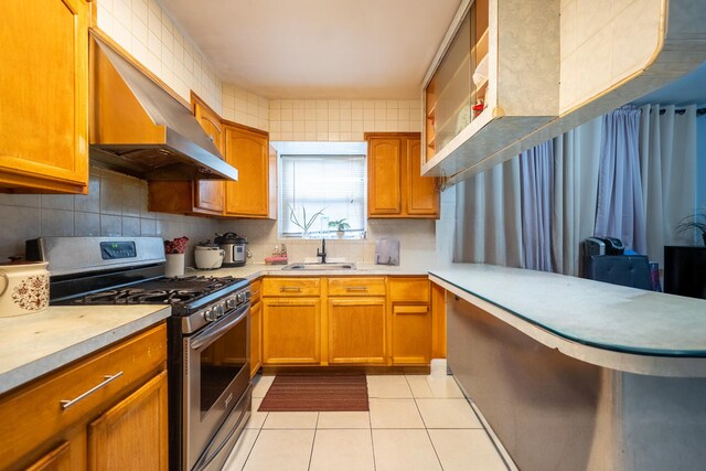 32-23 76th St, East Elmhurst, NY 11370 - kitchen featuring stainless steel gas stove, a sink, range hood, light countertops, and light tile patterned floors