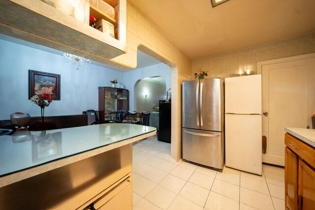 32-23 76th St, East Elmhurst, NY 11370 - kitchen featuring freestanding refrigerator, arched walkways, and light tile patterned floors
