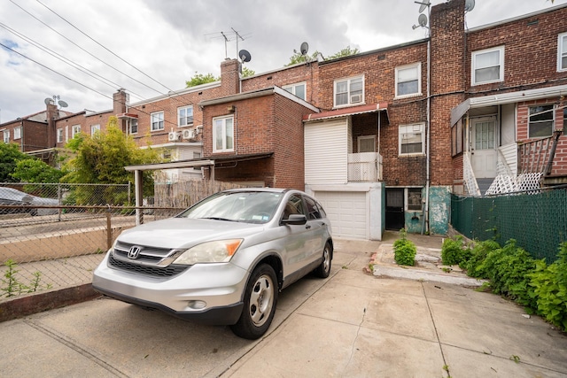 32-23 76th St, East Elmhurst, NY 11370 - view of front of home with concrete driveway, a garage, brick siding, and a chimney
