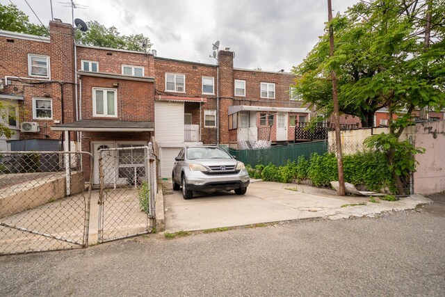 32-23 76th St, East Elmhurst, NY 11370 - view of front facade featuring an attached garage, a gate, concrete driveway, and brick siding