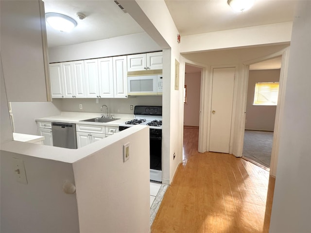 79 S Pointe Cir S Unit 79, Coram, NY 11727 - kitchen with white appliances, a sink, white cabinets, light wood-type flooring, and light countertops