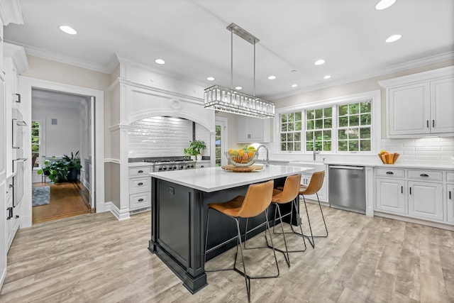 27 Olmsted Rd, Scarsdale, NY 10583 - kitchen featuring dishwasher, light countertops, tasteful backsplash, white cabinets, and a kitchen island with sink