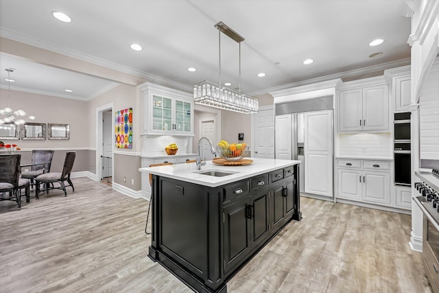 27 Olmsted Rd, Scarsdale, NY 10583 - kitchen with dark cabinetry, a sink, high end appliances, white cabinetry, and light countertops
