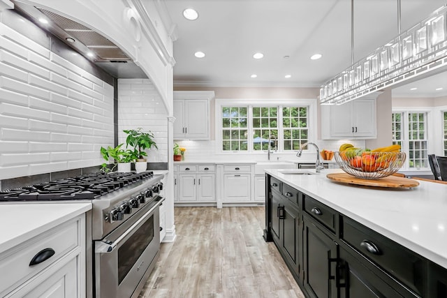 27 Olmsted Rd, Scarsdale, NY 10583 - kitchen with high end range, white cabinets, dark cabinetry, a sink, and decorative backsplash