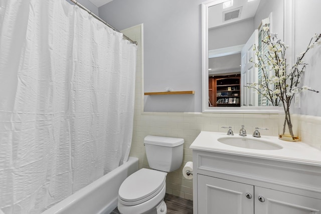27 Olmsted Rd, Scarsdale, NY 10583 - bathroom featuring vanity, toilet, shower / bath combo with shower curtain, tile walls, and a wainscoted wall