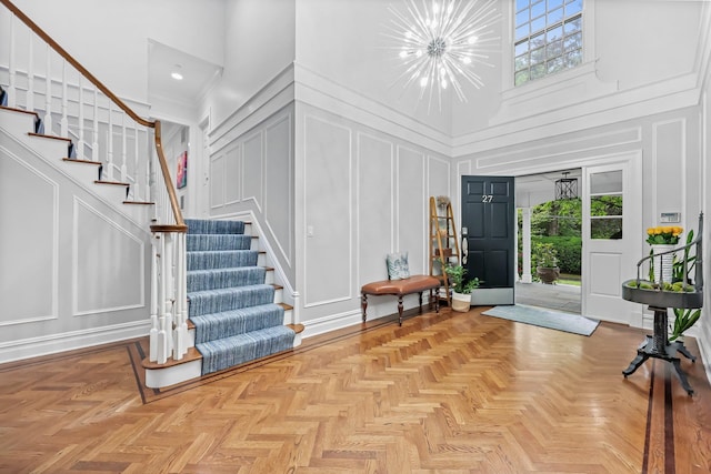 27 Olmsted Rd, Scarsdale, NY 10583 - entrance foyer with a decorative wall, a chandelier, stairway, and a high ceiling