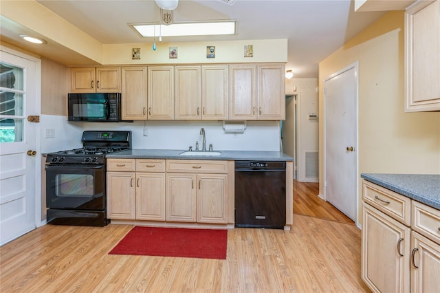 4 Roland Ct, Nanuet, NY 10954 - kitchen featuring black appliances, light brown cabinetry, light wood finished floors, and a skylight