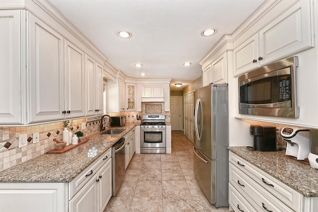 8 Thunder Rd, Miller Place, NY 11764 - kitchen featuring appliances with stainless steel finishes, a sink, decorative backsplash, light stone countertops, and recessed lighting