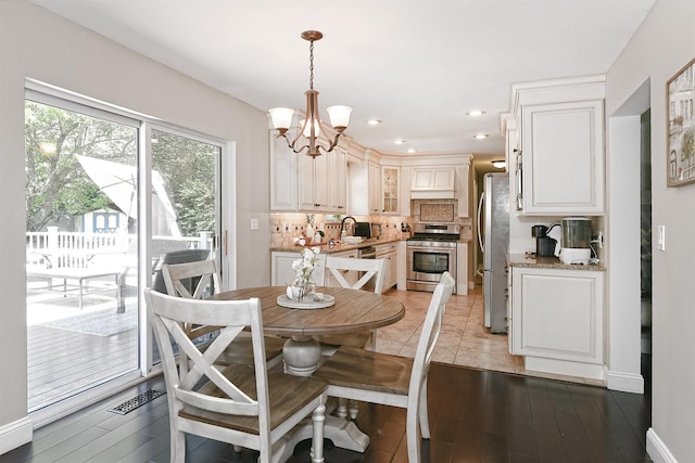 8 Thunder Rd, Miller Place, NY 11764 - dining area with a chandelier, recessed lighting, light wood-style floors, and baseboards