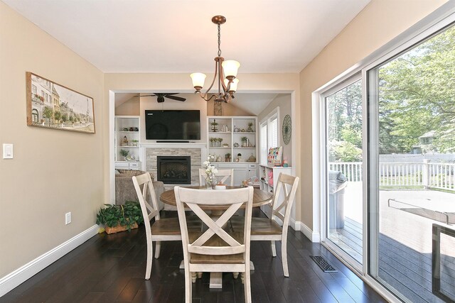 8 Thunder Rd, Miller Place, NY 11764 - dining area featuring baseboards, a stone fireplace, ceiling fan, and dark wood-style flooring