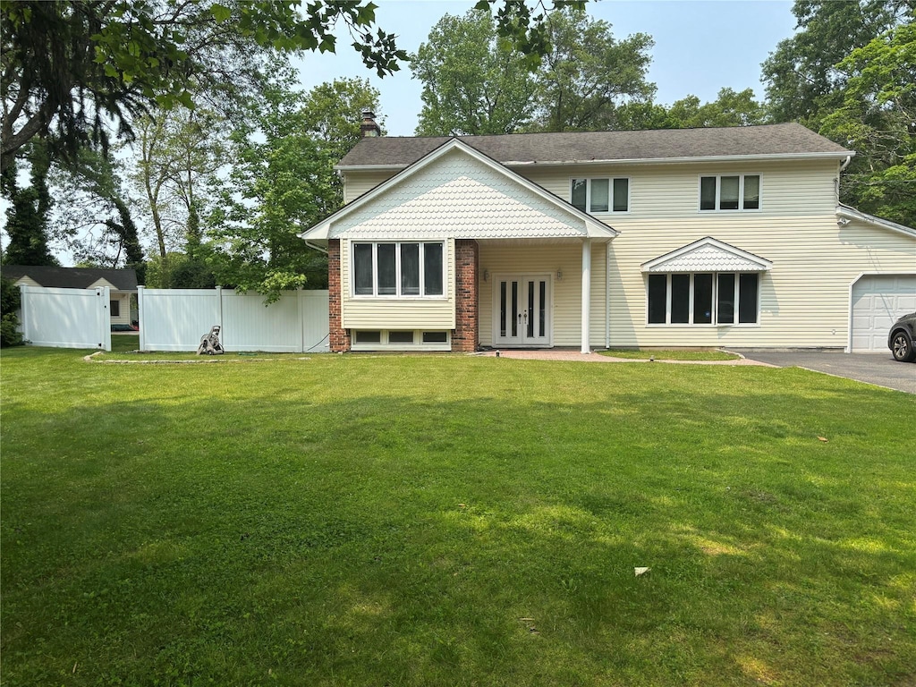 6 Attridge Ct, Melville, NY 11747 - view of front facade featuring french doors, a garage, a chimney, and asphalt driveway