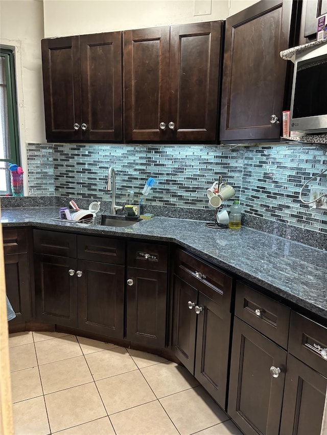 1920 S Mcgraw Ave S Unit 7D, Bronx, NY 10462 - kitchen with light tile patterned floors, tasteful backsplash, dark brown cabinetry, and dark stone counters