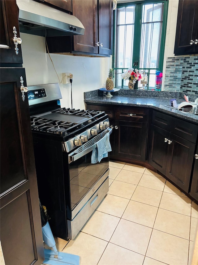 1920 S Mcgraw Ave S Unit 7D, Bronx, NY 10462 - kitchen featuring stainless steel gas range oven, range hood, decorative backsplash, light tile patterned floors, and dark stone countertops