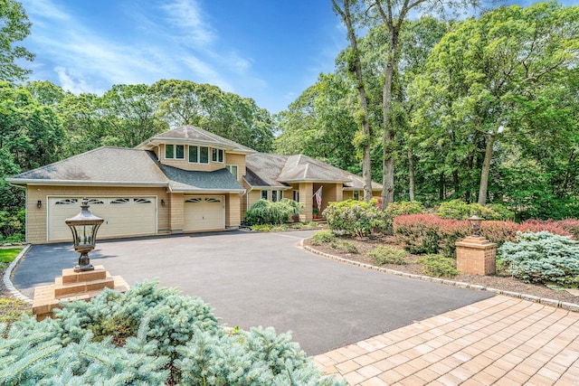 6 Ring Neck Ct, Wading River, NY 11792 - view of front facade with a garage, driveway, roof with shingles, and view of wooded area