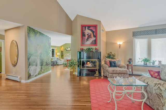 6 Ring Neck Ct, Wading River, NY 11792 - living area with a baseboard radiator, wood finished floors, a glass covered fireplace, and high vaulted ceiling