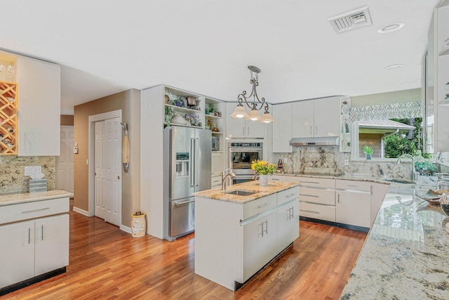 6 Ring Neck Ct, Wading River, NY 11792 - kitchen with stainless steel appliances, tasteful backsplash, under cabinet range hood, light wood-style floors, and open shelves