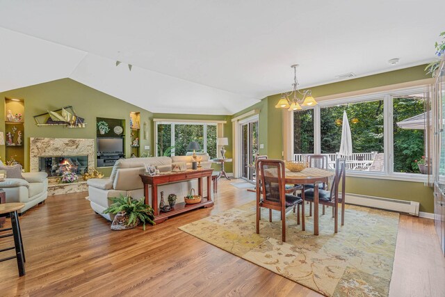 6 Ring Neck Ct, Wading River, NY 11792 - dining area with plenty of natural light, lofted ceiling, a chandelier, light wood-style floors, and a baseboard radiator