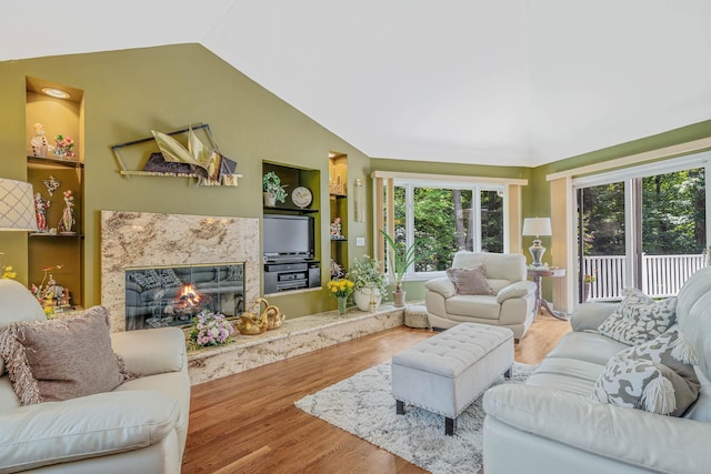 6 Ring Neck Ct, Wading River, NY 11792 - living area with wood finished floors, vaulted ceiling, a high end fireplace, and built in shelves