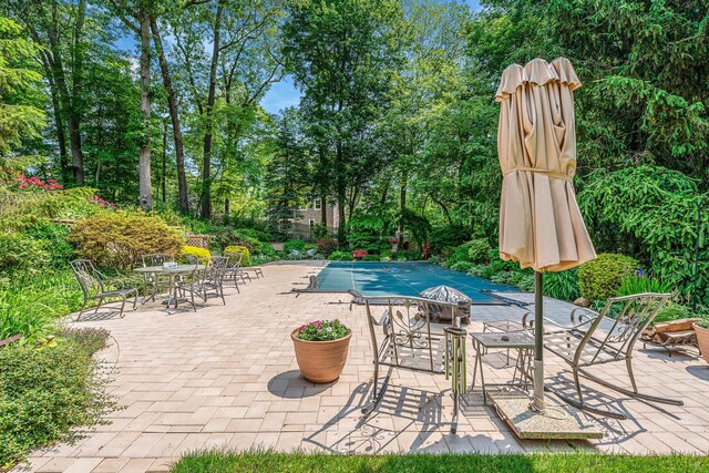 6 Ring Neck Ct, Wading River, NY 11792 - view of swimming pool featuring a patio area, a covered pool, outdoor dining area, and view of scattered trees