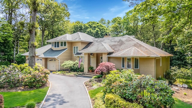 6 Ring Neck Ct, Wading River, NY 11792 - view of front of property featuring a shingled roof, a chimney, asphalt driveway, a garage, and view of scattered trees