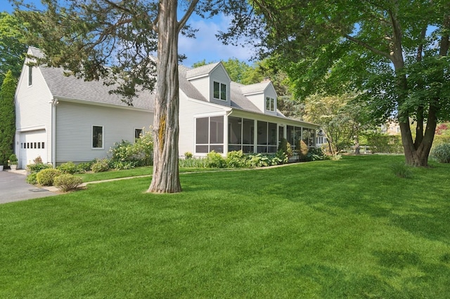26405 Main Rd, Cutchogue, NY 11935 - back of house with a chimney, a sunroom, a lawn, an attached garage, and a shingled roof
