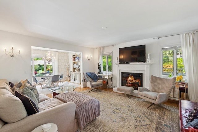 26405 Main Rd, Cutchogue, NY 11935 - living room with healthy amount of natural light, a glass covered fireplace, a chandelier, and wood finished floors