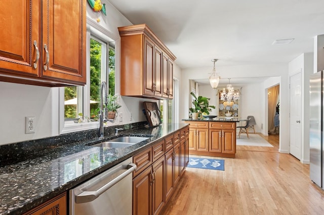 26405 Main Rd, Cutchogue, NY 11935 - kitchen featuring appliances with stainless steel finishes, light wood-type flooring, brown cabinets, pendant lighting, and dark stone counters