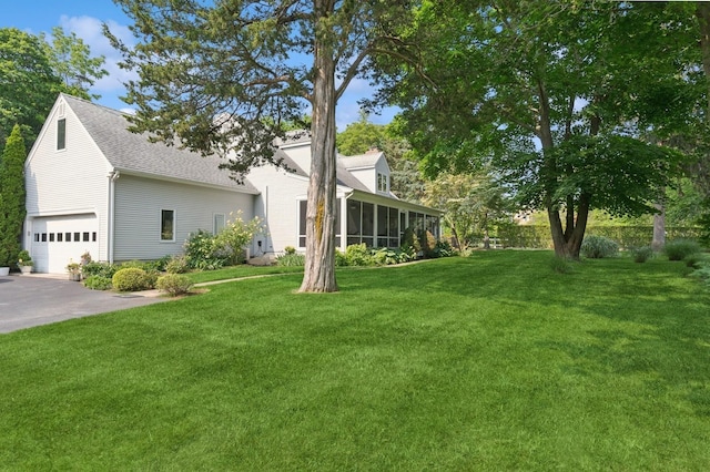 26405 Main Rd, Cutchogue, NY 11935 - view of grassy yard with a sunroom, an attached garage, and driveway