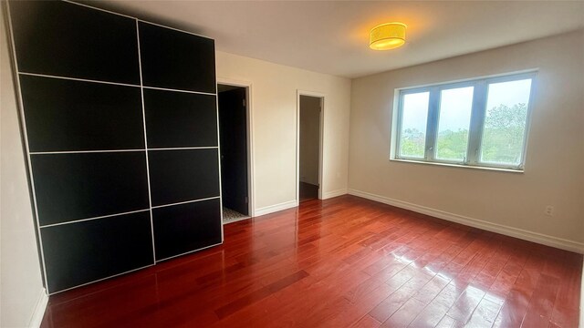 8510 Elmhurst Ave Unit 6B, Elmhurst, NY 11373 - unfurnished bedroom with wood finished floors and baseboards