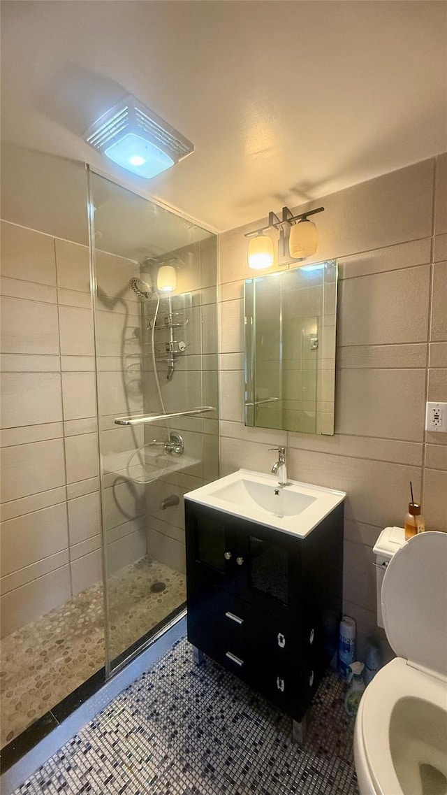 8510 Elmhurst Ave Unit 6B, Elmhurst, NY 11373 - bathroom featuring a stall shower, tile walls, vanity, and toilet